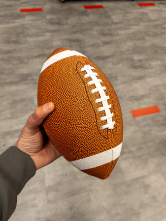A person holding a football in their hand.