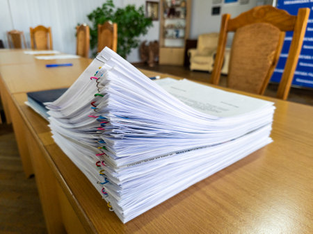 A stack of papers sitting on top of a wooden table.の写真素材