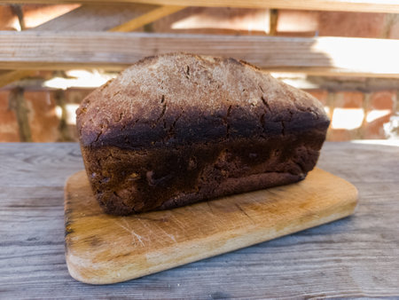 A loaf of bread sitting on top of a wooden board.の写真素材