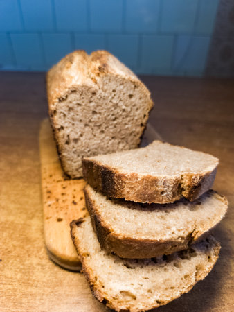 A sliced loaf of bread sitting on top of a wooden cutting board.の写真素材
