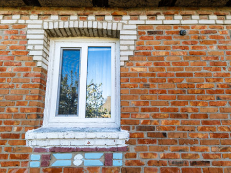 A brick wall with a window on the side of it.の写真素材