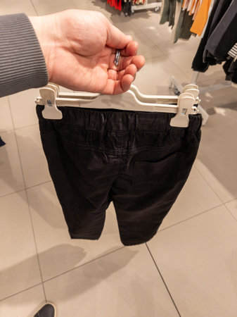 A person holding a pair of black shorts on a hanger.の写真素材