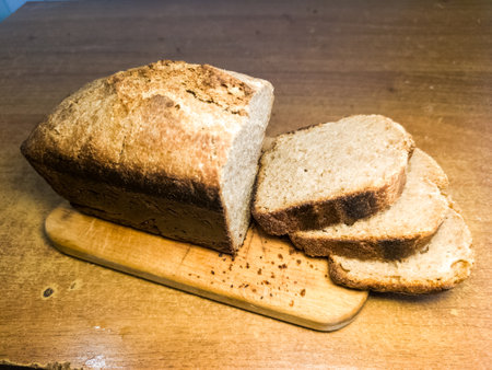 A loaf of bread sitting on top of a wooden board.の写真素材