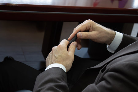 A man in a suit sitting at a desk writing on a piece of paper.の写真素材