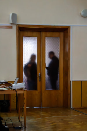A person standing in front of a wooden door in a room.の写真素材