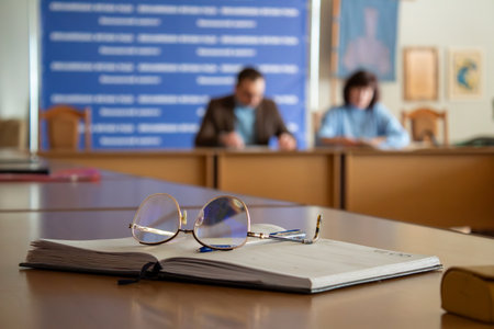 A pair of glasses sitting on top of a book on a table.の写真素材