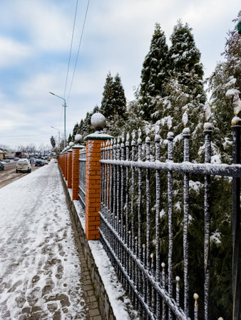 A snow covered fence on the side of a road.の写真素材