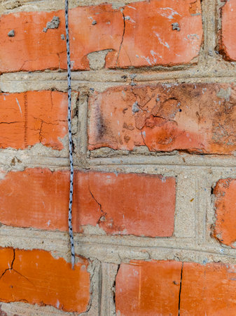 A brick wall with a rope attached to it.の写真素材