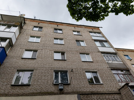 A tall brick building with many windows and balconies.の写真素材