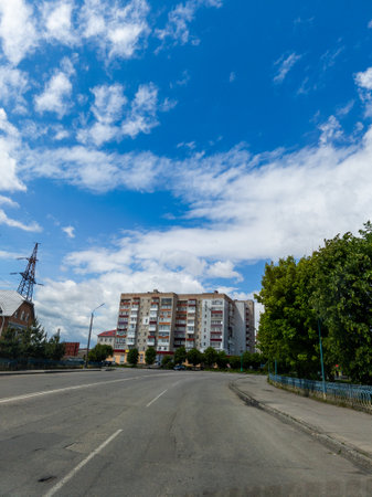 An empty street in front of a tall building under a blue sky.の写真素材