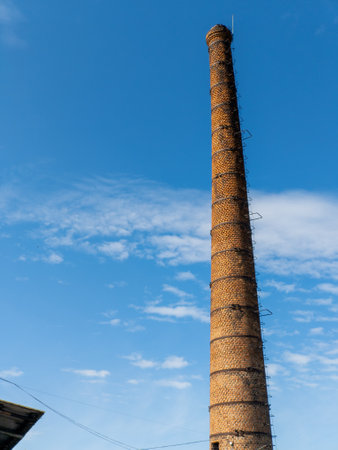 A tall brick chimney with a blue sky in the background.の写真素材