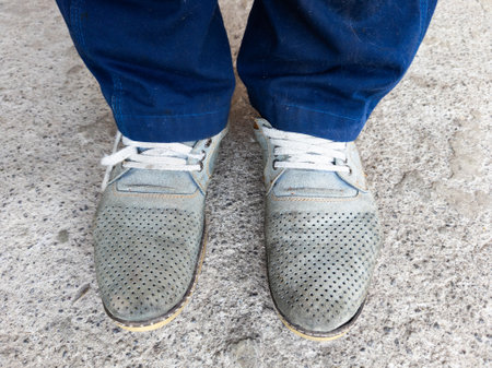 A person wearing a pair of blue jeans and gray shoes.の写真素材