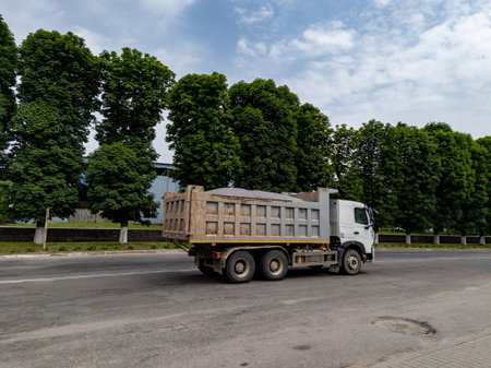 The truck filled with a load rides along the road.の写真素材