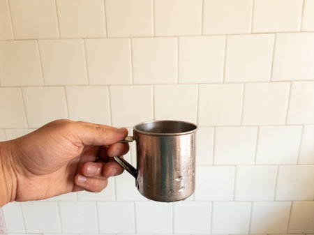 A person holding a stainless steel mug in their hand.の写真素材
