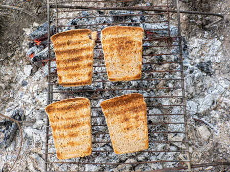 Four slices of bread are cooking on a grill