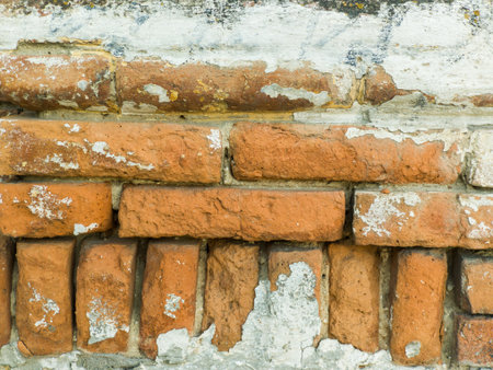 A brick wall with peeling paint on it.の写真素材