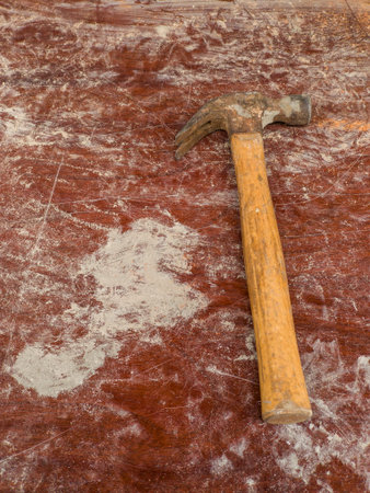 A hammer sitting on top of a wooden table.