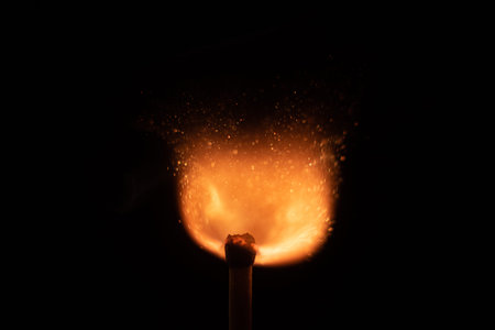 Ignition of match with sparks isolated on black background