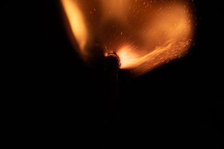 Ignition of match with sparks isolated on black background
