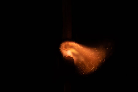 Ignition of match with sparks isolated on black background