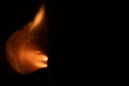 Ignition of match with sparks isolated on black background