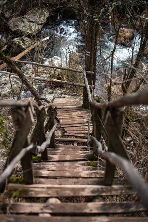 Winding wooden bridge over a river broken symmetry natural explore travel copy spaceの写真素材
