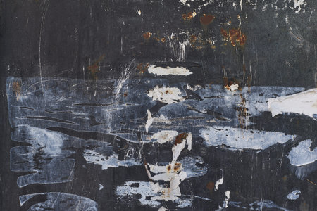 Plate of metal rusty texture with traces of black paint faint color corroded with age