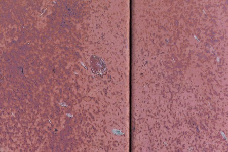 Plate of metal rusty texture with traces of red paint faint color corroded with age in Sofia,...