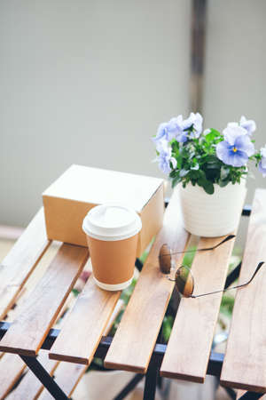 Take Away order from restaurant - bow with fresh made food and cup of coffee on the wooden table.の写真素材
