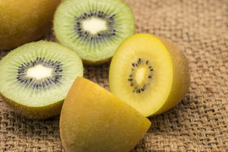 Fresh green and yellow kiwi fruits on sackclothの写真素材