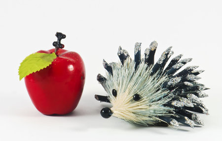 Decorative hedgehog with apple situated on white backgroundの写真素材