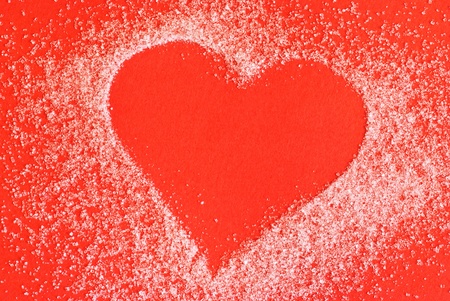 Heart made of sugar on red backgroundの写真素材