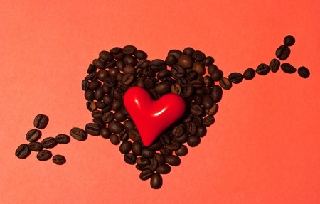 Little red heart in big coffee heart with arrowの写真素材