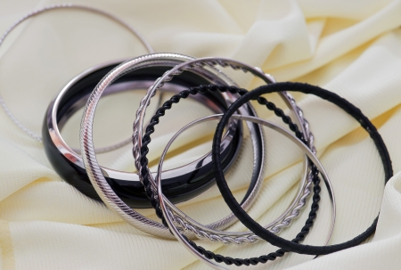 Metal bracelets on a background of yellow fabric.の写真素材