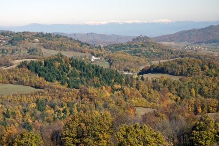 Colorful autumn landscape across rural, hilly countryside. Banska Stiavnica city with snowy hills of the Low Tatras at the background.の写真素材
