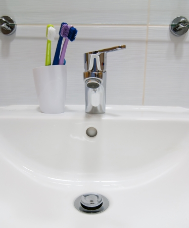 Empty white sink and toothbrushes.の写真素材