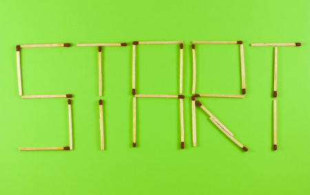 Word Start made of matchsticks isolated on green background.の写真素材
