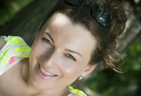 Smiley cheerful young brunette in park.の写真素材