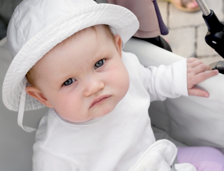 Baby girl looks out of a stroller.の写真素材