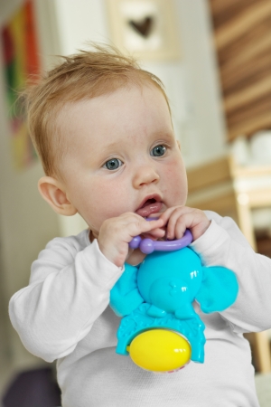 Cute caucasian baby girl with a toy.の写真素材