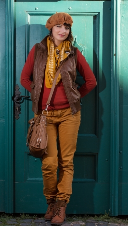 Beautiful caucasian woman standing before the closed turquoise door.の写真素材