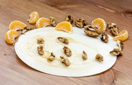 Christmas wafer with honey, walnuts and mandarin oranges on the wooden table.の写真素材
