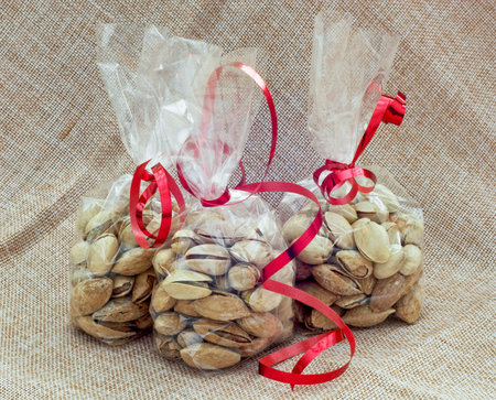 Pistachios packed in mini bags with red bows.の写真素材