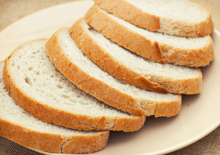 Sliced wheaten bread on a plate. Food theme.