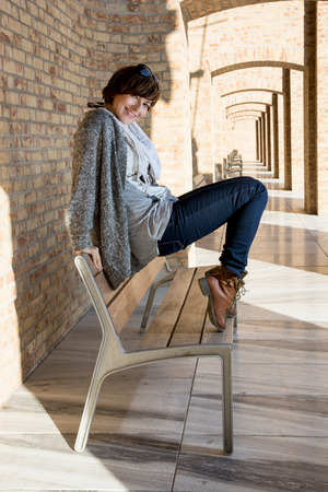 Beautiful caucasian brunette posing on a bench. Beautiful caucasian brunette posing on a bench.