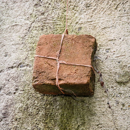 Old red brick hanging on a twine.