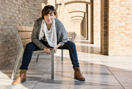 Beautiful young brunette posing on a bench. Beauty and fashion. Beautiful young brunette posing on a bench. Beauty and fashion.