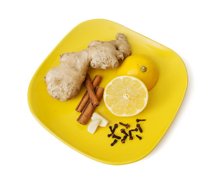 Ginger, cinnamon, lemon, garlic and cloves on the plate. Healthy food.