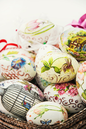 Wicker basket full of various painted Easter eggs. Spring time.の写真素材