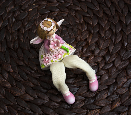Decorative doll sitting on the dark background. Children's toys.の写真素材